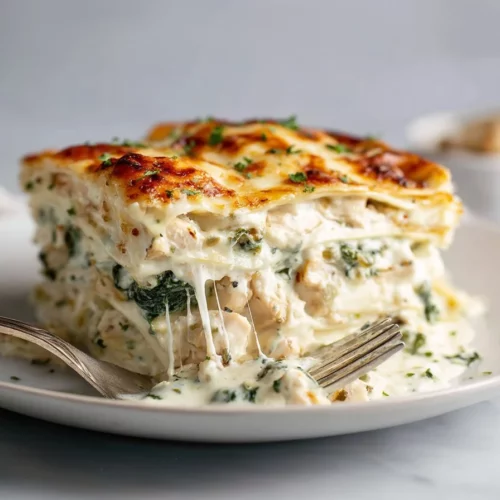 A delicious serving of easy white chicken lasagna with spinach on a plate.