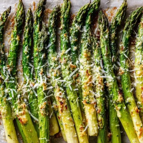 Oven baked asparagus with garlic and parmesan on a white plate