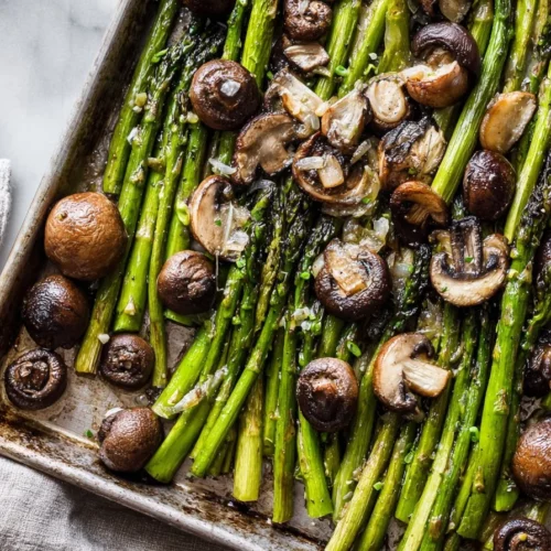 Plate of roasted asparagus and mushrooms seasoned with spices.