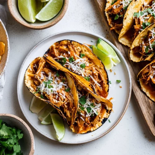 Slow cooker shredded BBQ chicken tacos topped with fresh ingredients