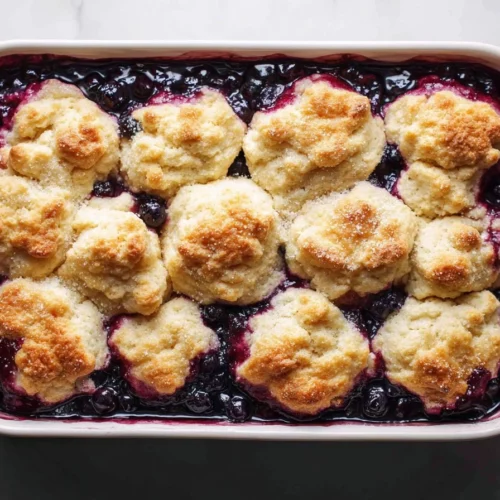 Vegan blueberry cobbler dessert topped with fresh blueberries.
