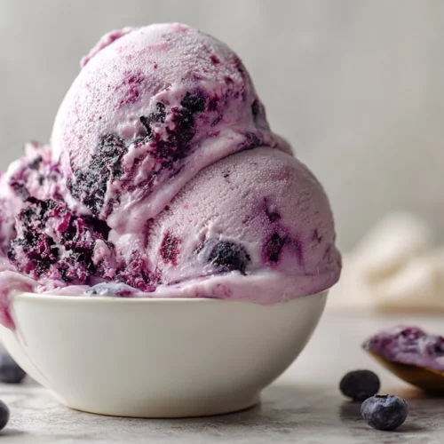 Delicious no-churn blueberry ice cream served in a dish with fresh blueberries