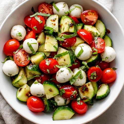 Fresh Cucumber Caprese Salad with mozzarella and tomatoes on a plate