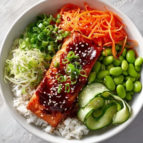 Delicious Asian salmon bowl with vegetables and rice, garnished with sesame seeds